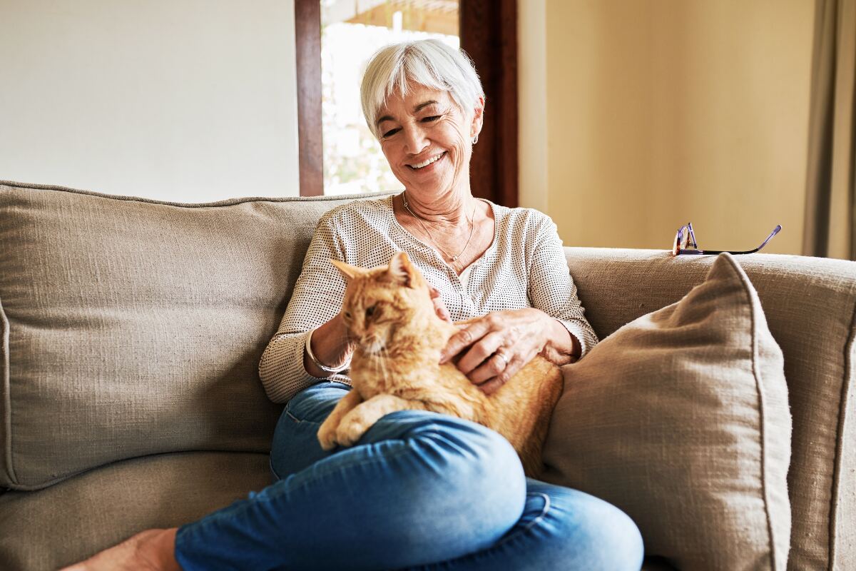 SH-How Animals Can Support Mental Health Image Option 2 Image of a mature women sitting on couch with an orange cat